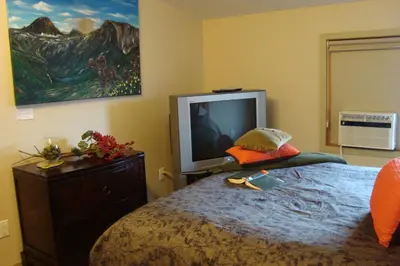 a bedroom with a bed and a tv on the wall at YPC Fitness & Accomodations in Invermere