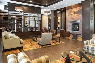a lobby with couches and chairs and a fireplace at Four Points by Sheraton Edmonton International Airport in Nisku
