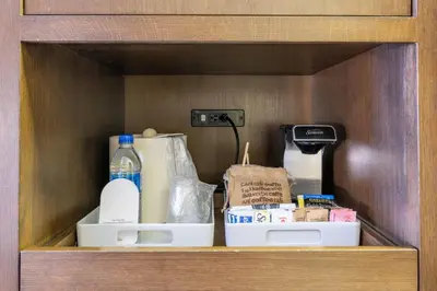 a wooden cabinet with some items on a shelf at Four Points by Sheraton Edmonton International Airport in Nisku