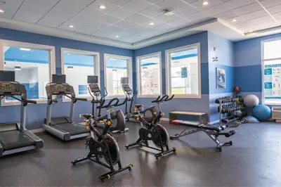 a gym with exercise bikes and ellipticals in a room with windows at Four Points by Sheraton Edmonton International Airport in Nisku