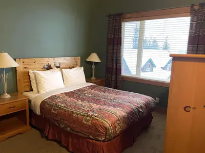 a bedroom with a bed and a window at Cornerstone Lodge by Park Vacation Management in Fernie
