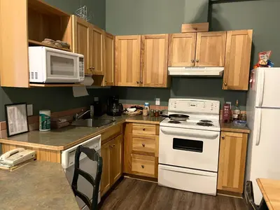 a kitchen with wooden cabinets and a white stove top oven at Cornerstone Lodge by Park Vacation Management in Fernie