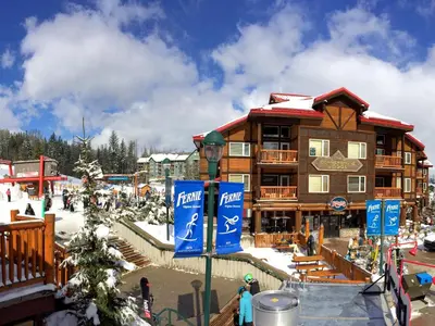 a ski lodge in the snow in front of a building at Cornerstone Lodge by Park Vacation Management in Fernie