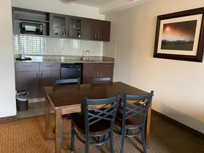 a kitchen with a wooden table and chairs at Ramada by Wyndham Creston in Creston