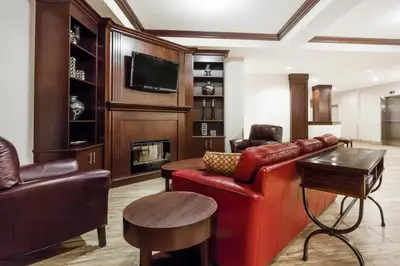 a living room with a red leather couch and a tv at Ramada by Wyndham Creston in Creston