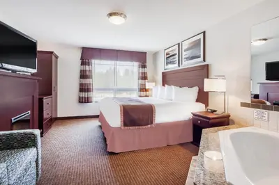 a hotel room with a bed and a bath tub at Ramada by Wyndham Creston in Creston