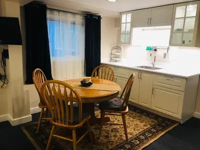 a kitchen with a table and chairs and a sink at Cambie Lodge in Vancouver
