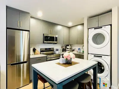 a kitchen with a table and a washer and dryer at Joe's Contemporary 2 King Bedrooms Vacation Home in Canmore in Canmore