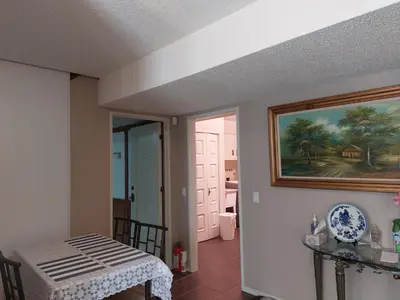 a dining room with a table and a painting on the wall at Green Village in Calgary