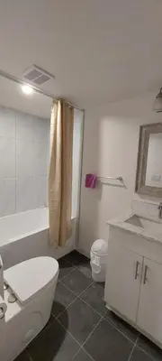 a bathroom with a toilet and a tub and a sink at Green Village in Calgary