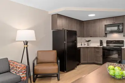 a kitchen with a black refrigerator and a chair at Worldmark Whistler Sundance in Whistler