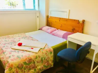 a bedroom with a bed and a desk and a blue chair at Good location in Surrey