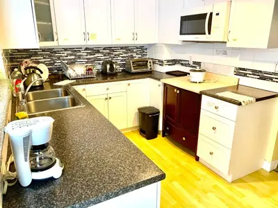 a kitchen with white cabinets and a counter top at Good location in Surrey