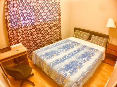 a bedroom with a bed and a desk and a chair at Good location in Surrey