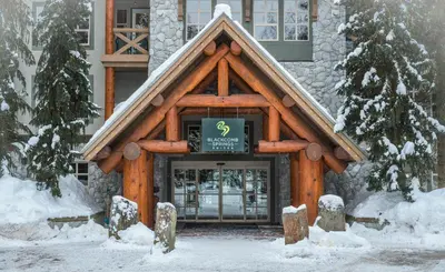 a log building with a sign on the front of it at Blackcomb Springs Suites by CLIQUE in Whistler