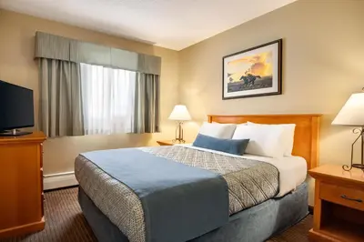 a hotel room with a bed and a flat screen tv at Travelodge by Wyndham Edson in Edson
