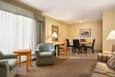 a living room filled with furniture and a dining room at Travelodge by Wyndham Edson in Edson