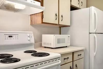 a kitchen with a white stove and a microwave at Travelodge by Wyndham Edson in Edson