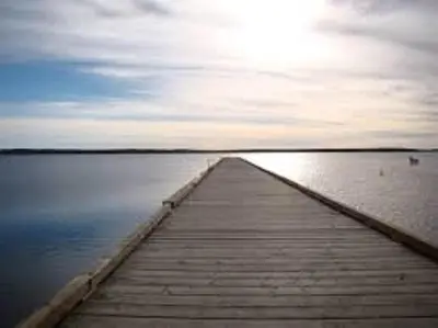 a wooden dock in the middle of a body of water at Shoreside Inn & Suites in Wabamun