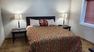 a bedroom with a bed and two lamps on tables at Shoreside Inn & Suites in Wabamun