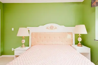a bedroom with green walls and a bed with two lamps at Harmony House in Richmond