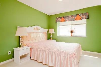 a green bedroom with a bed and a window at Harmony House in Richmond