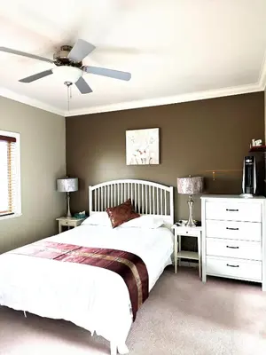 a bedroom with a bed and a ceiling fan at V.I.P. CLUB in Surrey