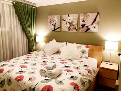 a bedroom with a bed with towels on it at Hannah's Heavenly Home in Surrey