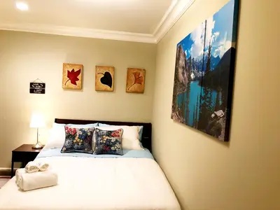 a bedroom with a bed with four pictures on the wall at Hannah's Heavenly Home in Surrey