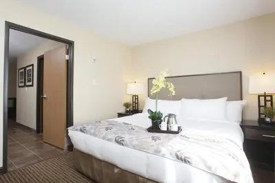a hotel room with a large bed with flowers on it at Pomeroy Inn & Suites at Olds College in Olds