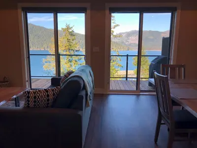 a living room with a couch and a view of a lake at Botany Bay by Eagle Reach Properties in Port Renfrew