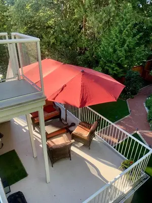 a patio with a red umbrella and some chairs at Beautiful Two Bedroom Suite in North Vancouver