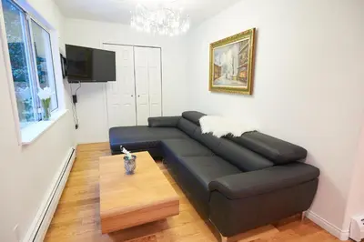 a living room with a couch and a tv at Beautiful Two Bedroom Suite in North Vancouver