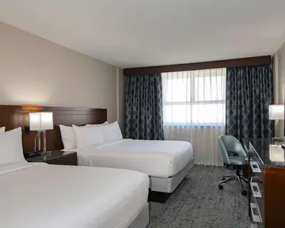 a hotel room with two beds and a desk at DoubleTree by Hilton - Kamloops in Kamloops