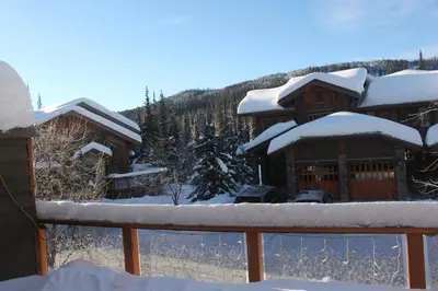 a log cabin with snow on the roof at Woodhaven # 8 in Sun Peaks in Sun Peaks