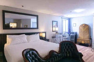 a bedroom with a large bed with a mirror on the wall at The Baker Hotel in Cranbrook