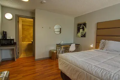 a bedroom with a bed and a desk and a bathroom at The Baker Hotel in Cranbrook