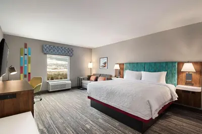 a large hotel room with a bed and a desk at Hampton Inn & Suites Kelowna, British Columbia, Canada in Kelowna