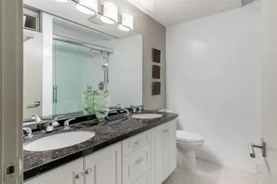 a bathroom with two sinks and a toilet at Kelowna Discovery in Kelowna