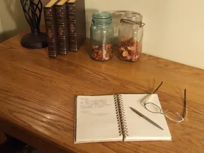 a desk with an open notebook and glasses and books at Country Encounters Accommodations in Coleman