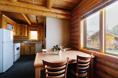 a kitchen with a wooden table and a window at Miette Mountain Cabins in Jasper