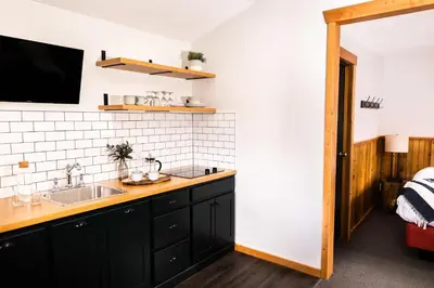 a kitchen with black cabinets and a sink at Miette Mountain Cabins in Jasper