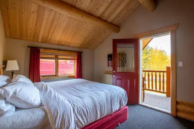 a bedroom with a bed and a sliding glass door at Miette Mountain Cabins in Jasper
