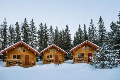 a couple of log homes in the snow at Miette Mountain Cabins in Jasper