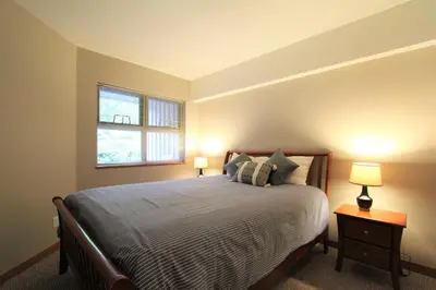 a bedroom with a bed with two lamps and a window at Lake Placid Lodge by Whistler Retreats in Whistler