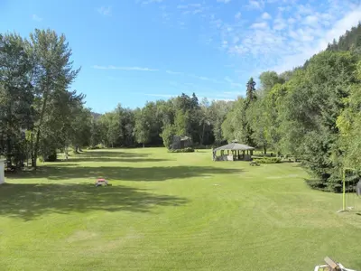a large field with a gazebo in the middle of it at Rivermount Motel in Little Fort