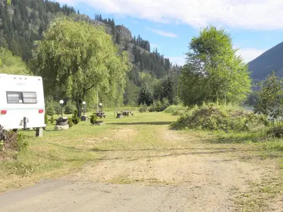 an rv parked on the side of a dirt road at Rivermount Motel in Little Fort