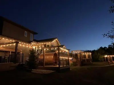 a house with lights on the side of it at night at Dragonfly Inn Loft Suite in Sherwood Park