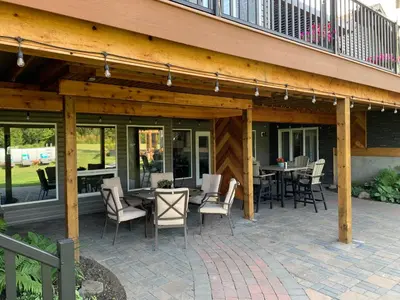a patio with tables and chairs and a balcony at Dragonfly Inn Loft Suite in Sherwood Park