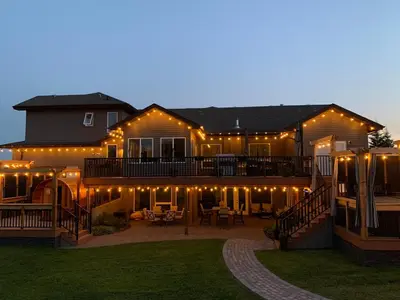 a large house with a deck with lights on it at Dragonfly Inn Loft Suite in Sherwood Park